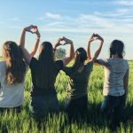 women forming heart gestures during daytime