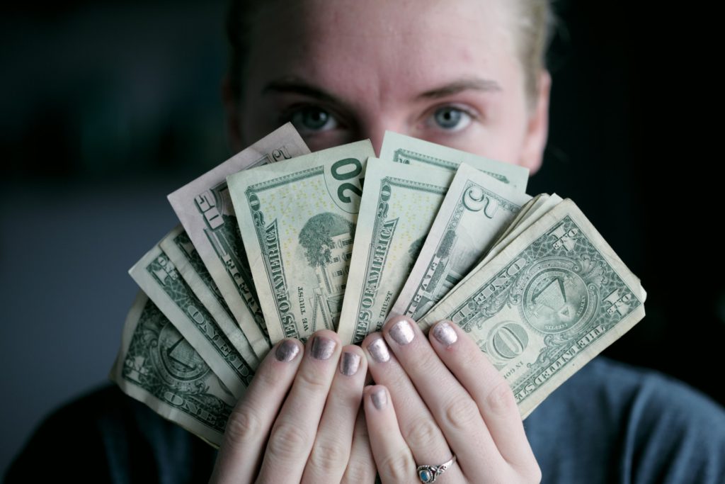 Person holding fan of US dollars