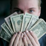 Person holding fan of US dollars